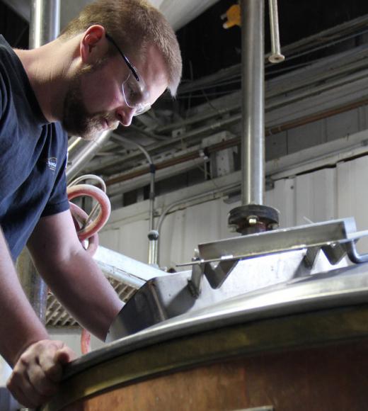 master brewers graduate Kevin Wright looking in kettle